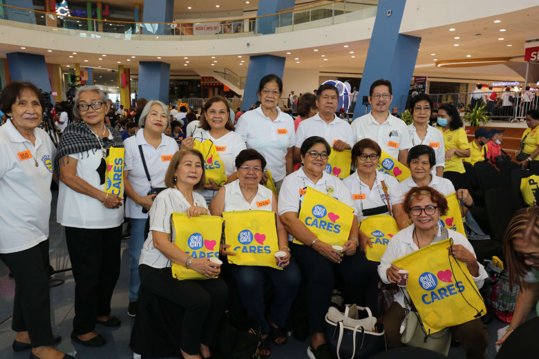 Senior citizen attendees pose for a photo op with their SM Cares emergency go-bags